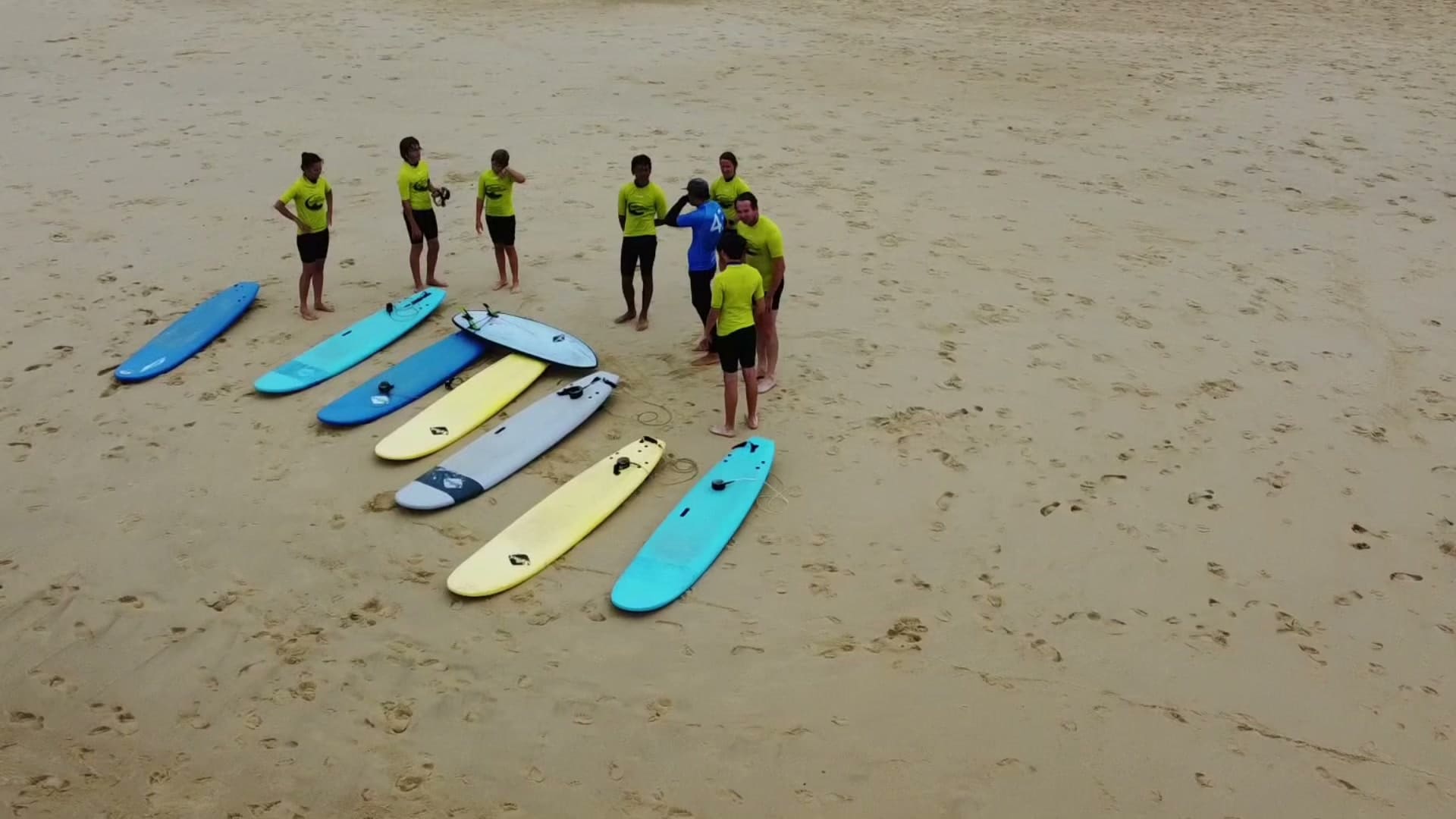 Cours de surf collectif Kiwadu vu du ciel — élèves autour du moniteur sur la plage du Penon à Seignosse